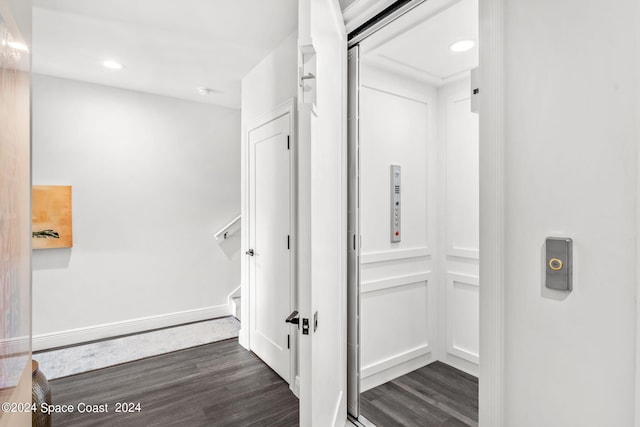 corridor featuring elevator and dark hardwood / wood-style flooring