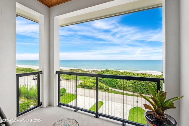 balcony with a water view and a beach view