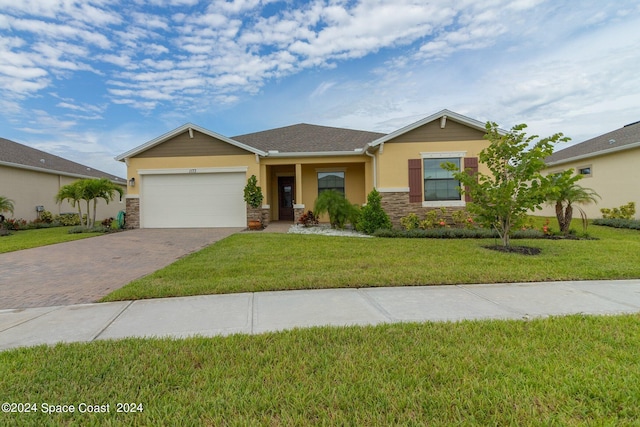 single story home featuring a front yard and a garage