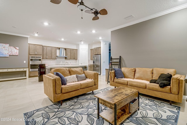 living room featuring ceiling fan, light tile patterned floors, sink, and ornamental molding