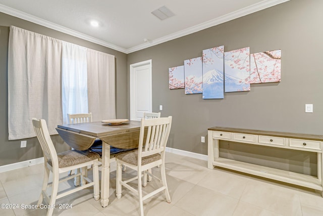 dining space with ornamental molding and light tile patterned floors