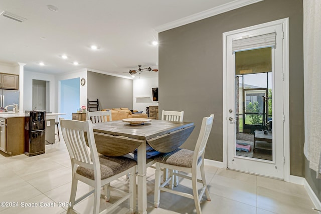 dining space featuring sink, light tile patterned flooring, and ornamental molding