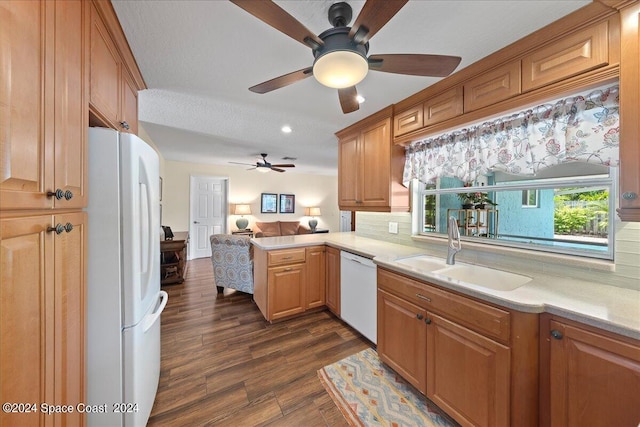 kitchen with kitchen peninsula, a textured ceiling, white appliances, sink, and dark hardwood / wood-style floors