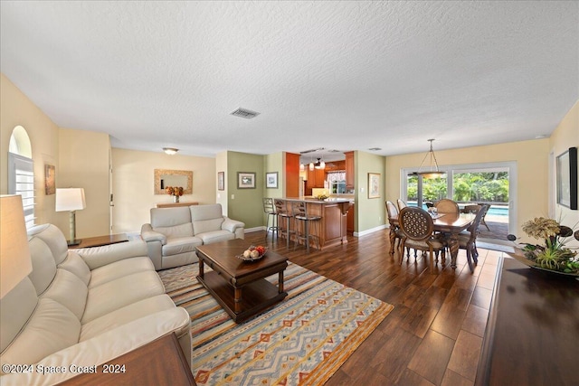 living room featuring dark hardwood / wood-style floors and a textured ceiling