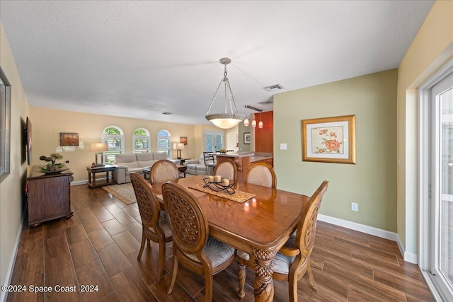 dining area featuring a textured ceiling and dark hardwood / wood-style floors