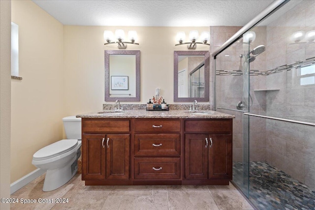 bathroom featuring vanity, toilet, an enclosed shower, and a textured ceiling