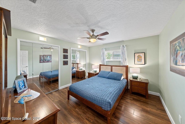 bedroom featuring dark hardwood / wood-style floors, ceiling fan, a textured ceiling, and two closets