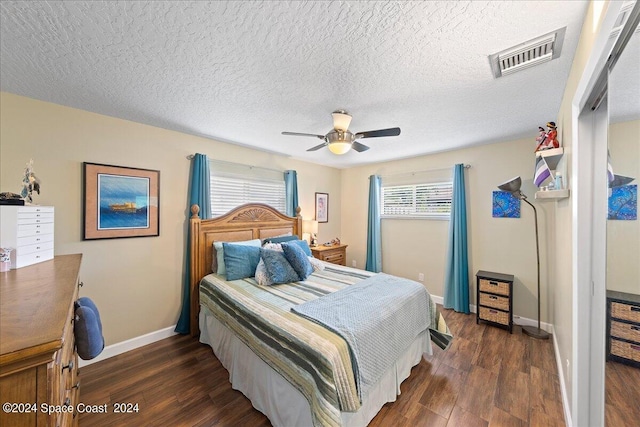 bedroom featuring a textured ceiling, ceiling fan, and dark wood-type flooring