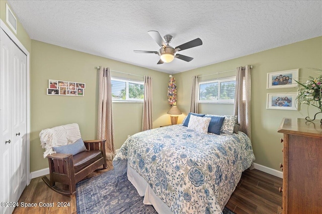 bedroom with a textured ceiling, ceiling fan, a closet, and dark hardwood / wood-style floors