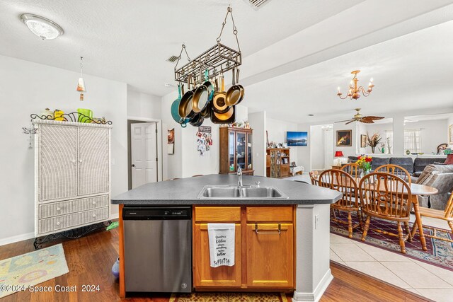 kitchen with an island with sink, dishwasher, sink, and dark hardwood / wood-style flooring