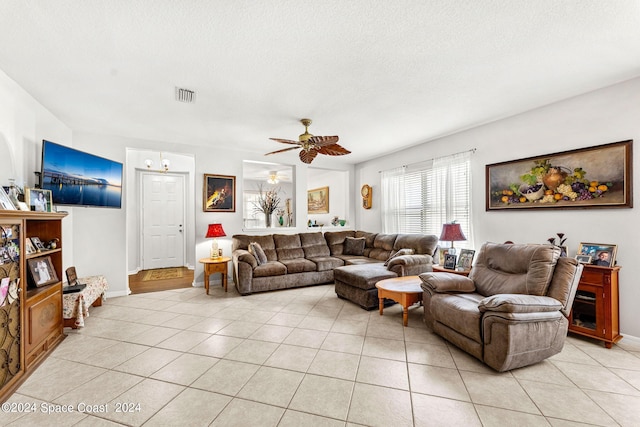 tiled living room featuring a textured ceiling and ceiling fan