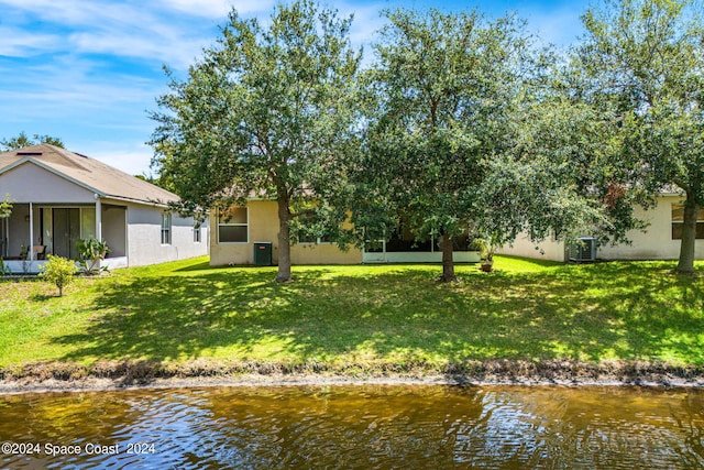 view of front of property featuring a water view, central AC, and a front yard