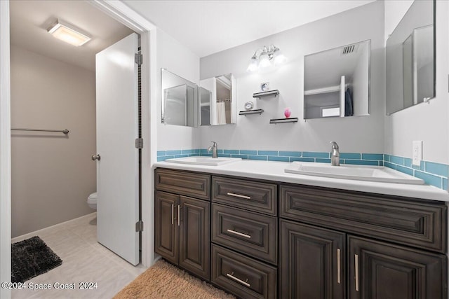 bathroom featuring tile patterned flooring, toilet, and vanity