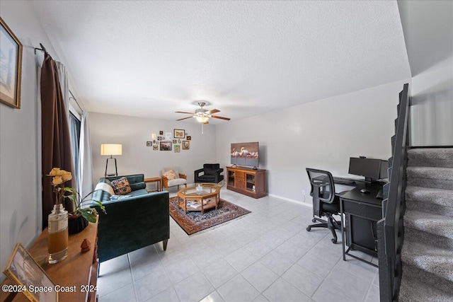 living room with a textured ceiling, ceiling fan, and light tile patterned floors