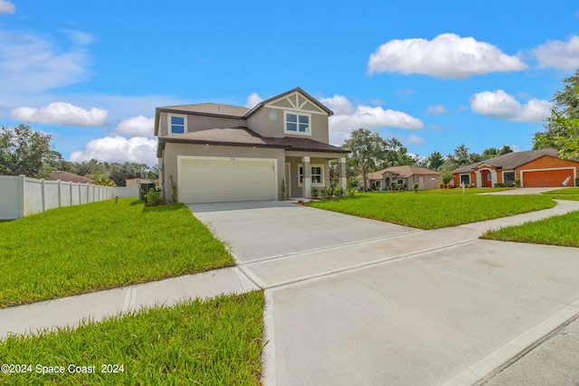 traditional home with stucco siding, an attached garage, a front yard, fence, and driveway