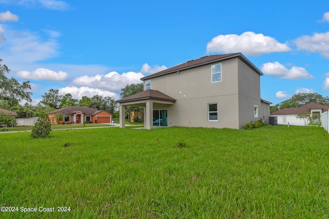 rear view of house featuring a yard, stucco siding, fence, and central air condition unit