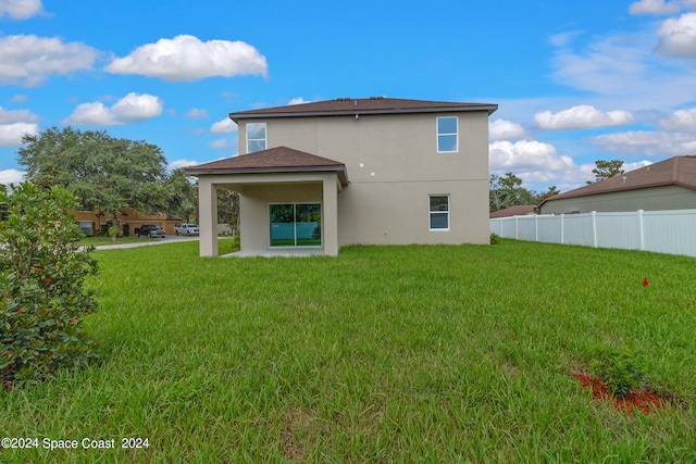 rear view of property with a lawn