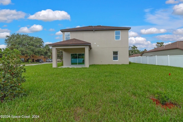 back of property featuring a patio, fence, a lawn, and stucco siding