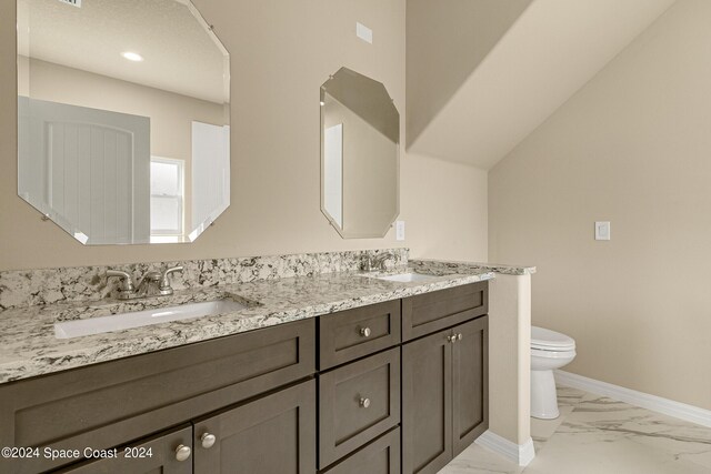 bathroom with toilet, vanity, and tile patterned floors