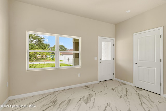 empty room featuring marble finish floor and baseboards