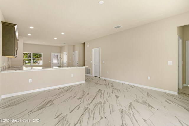 unfurnished living room with sink and light tile patterned floors