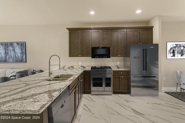 kitchen featuring dishwasher, refrigerator, sink, range with two ovens, and light tile patterned floors