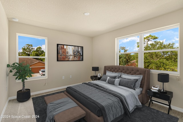 carpeted bedroom featuring a textured ceiling