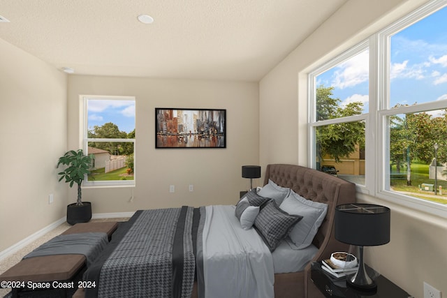 bedroom with a textured ceiling and baseboards