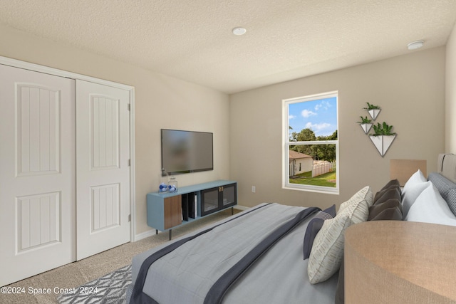 bedroom with carpet floors, a closet, a textured ceiling, and baseboards