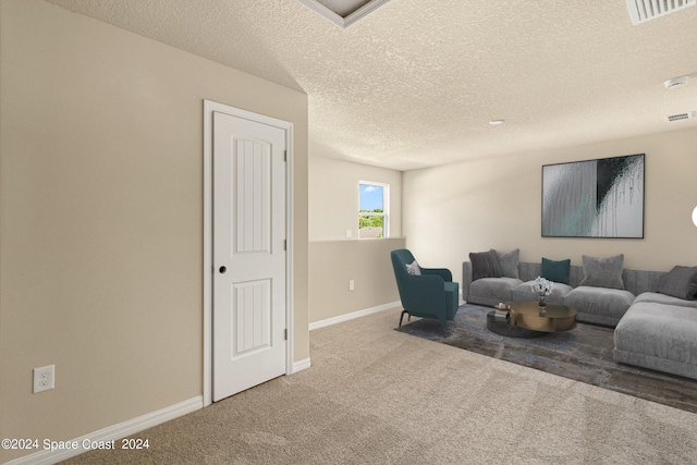 living room with carpet, a textured ceiling, visible vents, and baseboards