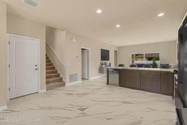 kitchen featuring light tile patterned flooring and dark brown cabinets