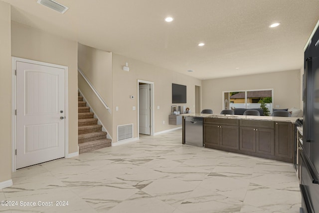 kitchen with a peninsula, marble finish floor, and visible vents