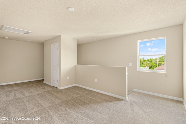 unfurnished room with a textured ceiling and carpet