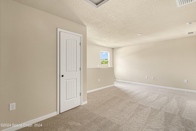 carpeted spare room featuring a textured ceiling