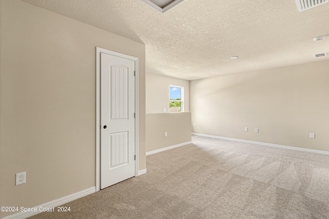 spare room with carpet flooring, visible vents, and baseboards