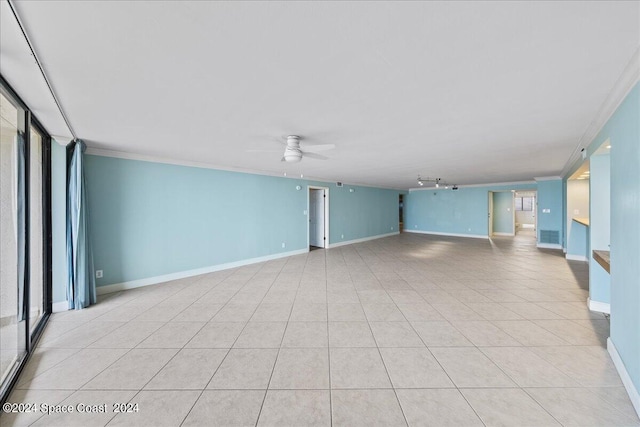 empty room with ceiling fan, light tile patterned floors, and crown molding