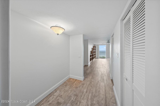 hallway with wood finished floors and baseboards