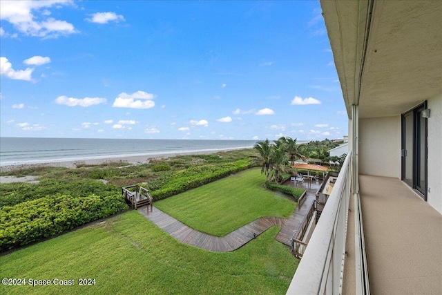 exterior space featuring a water view, a view of the beach, and a balcony