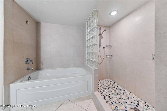 full bath featuring tiled shower, a garden tub, tile walls, and tile patterned floors