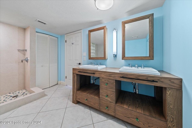 bathroom featuring double vanity, visible vents, a sink, and tile patterned floors