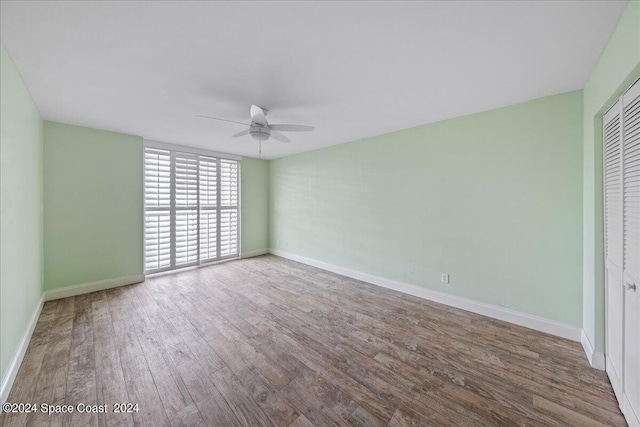 unfurnished bedroom with a ceiling fan, a closet, baseboards, and wood finished floors