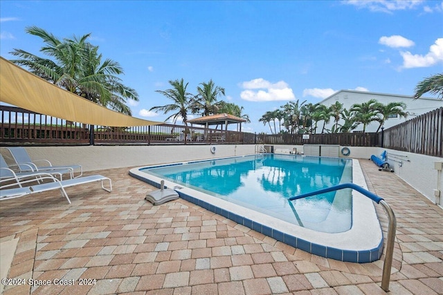 pool with a patio area, a fenced backyard, and a gazebo