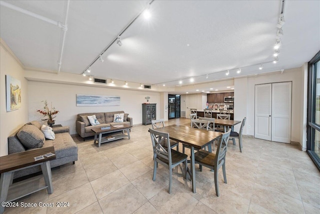 dining space featuring track lighting and light tile patterned floors