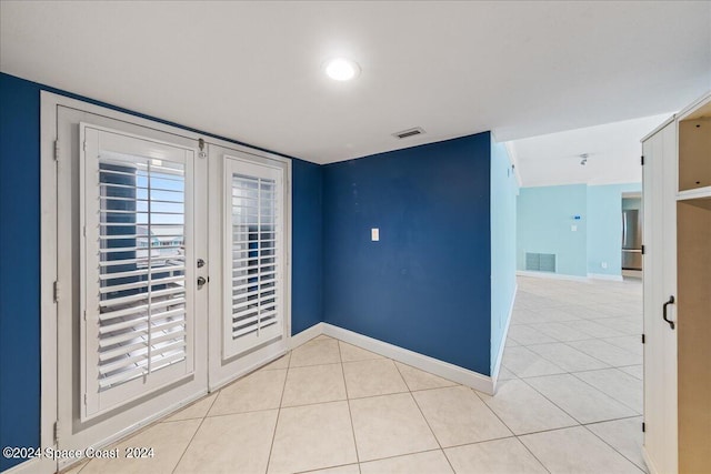 spare room with light tile patterned flooring and french doors