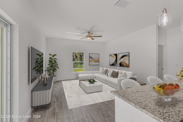 living room featuring ceiling fan and dark hardwood / wood-style floors