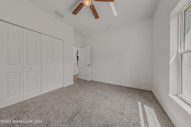 unfurnished bedroom with ceiling fan, carpet, and a closet