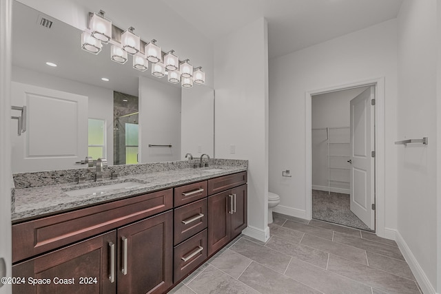 bathroom with tile patterned flooring, a shower with door, vanity, and toilet