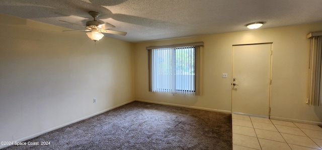 spare room featuring light carpet, a textured ceiling, and ceiling fan