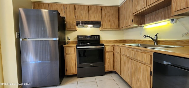 kitchen with light tile patterned floors, stainless steel appliances, sink, and butcher block countertops