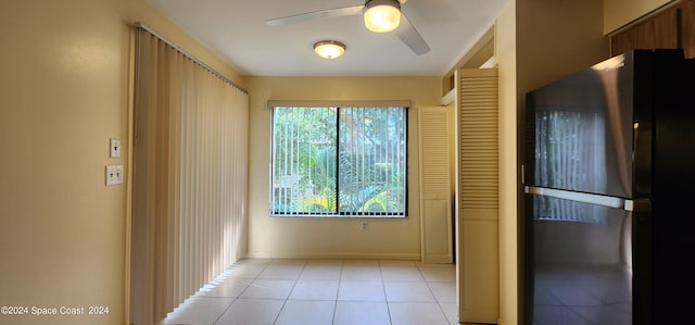 kitchen with black fridge, ceiling fan, and light tile patterned flooring